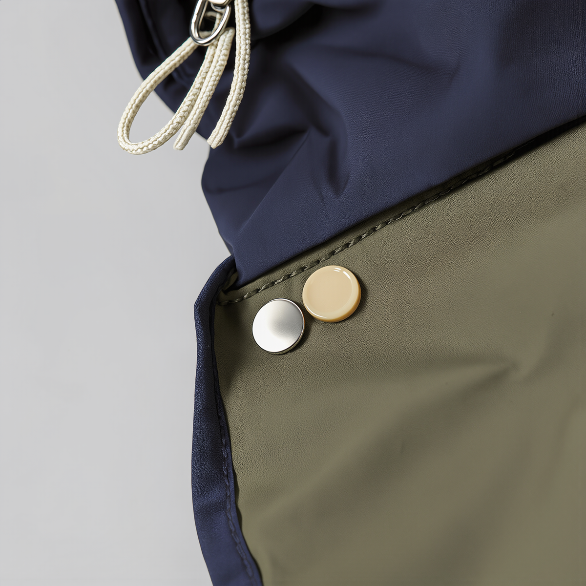 Detailaufnahme: Druckknöpfe, Kordelzug der Kapuze und dunkelblaue Einfassung am Rainmate Regencape